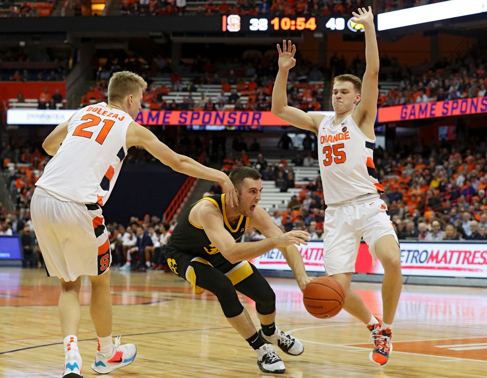 Iowa Hawkeyes guard Connor McCaffery (30) passes the ball between two defenders during the second half of their ACC/Big Ten Challenge game at the Carrier Dome in Syracuse, N.Y. on Tuesday, Dec 3, 2019. (Stephen Mally/hawkeyesports.com)