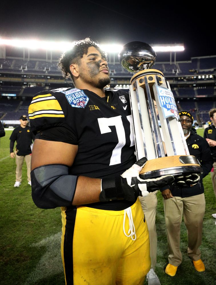 Iowa Hawkeyes offensive lineman Tristan Wirfs (74) celebrates with the Holiday Bowl trophy following their win against USC in the Holiday Bowl Friday, December 27, 2019 at San Diego Community Credit Union Stadium.  (Brian Ray/hawkeyesports.com)