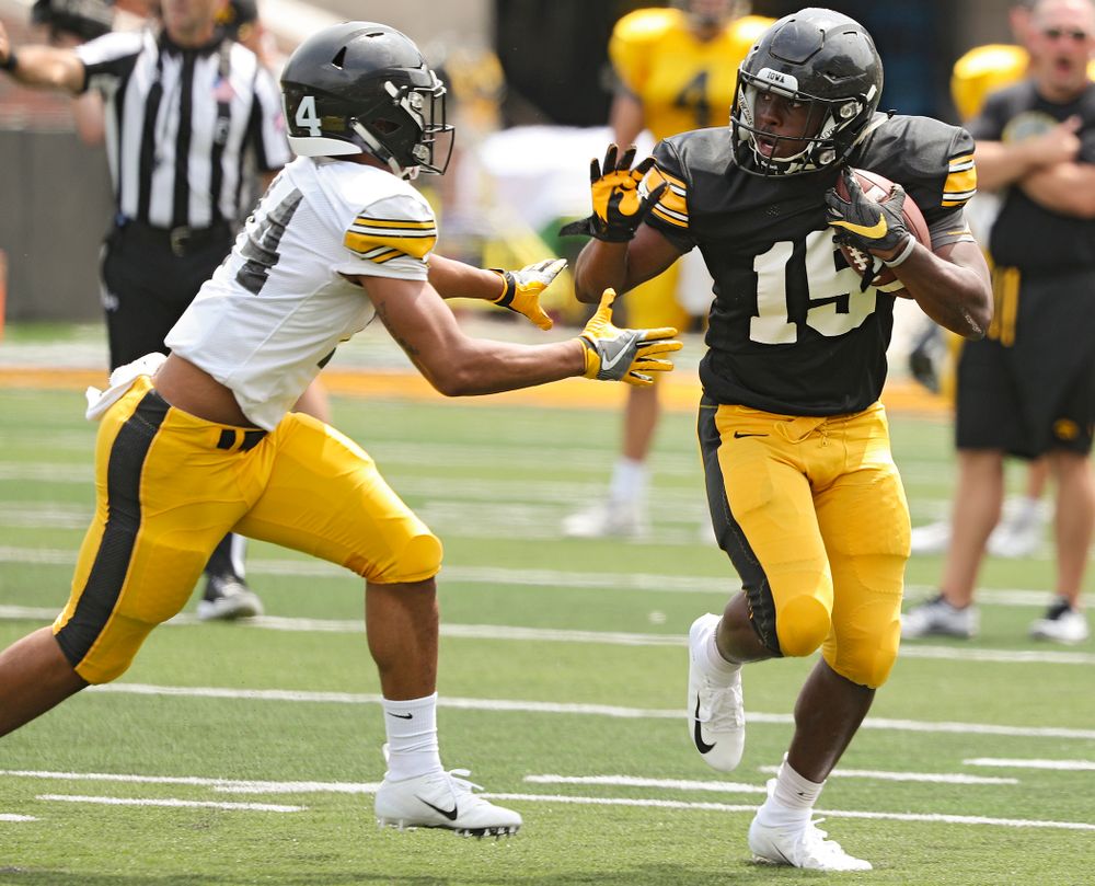 Iowa Hawkeyes running back Tyler Goodson (15) tries to hold off defensive back Daraun McKinney (14) during Fall Camp Practice No. 8 at Kids Day at Kinnick Stadium in Iowa City on Saturday, Aug 10, 2019. (Stephen Mally/hawkeyesports.com)