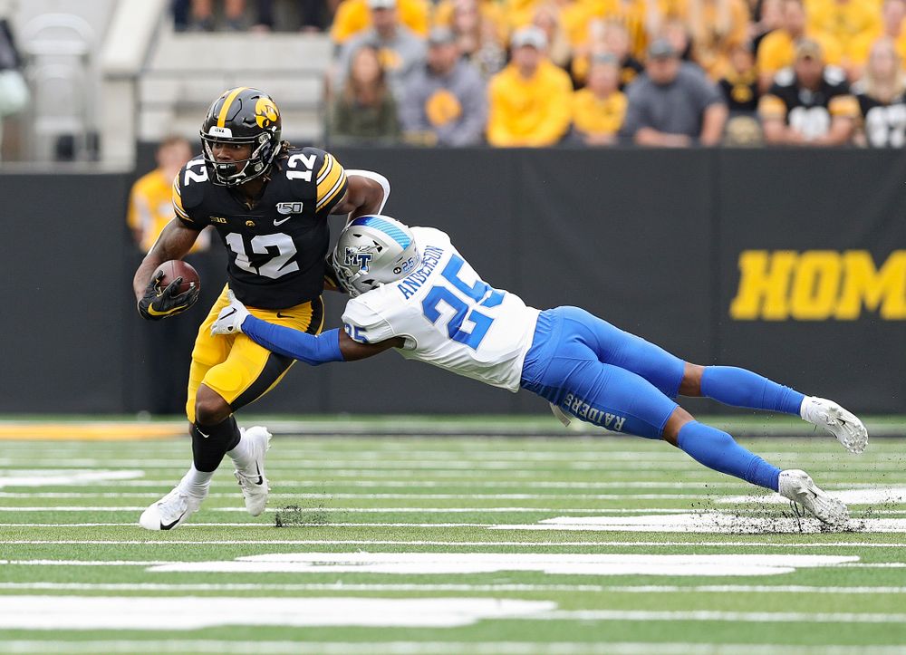 Iowa Hawkeyes wide receiver Brandon Smith (12) pulls away from a defender after catching a pass during the first quarter of their game at Kinnick Stadium in Iowa City on Saturday, Sep 28, 2019. (Stephen Mally/hawkeyesports.com)