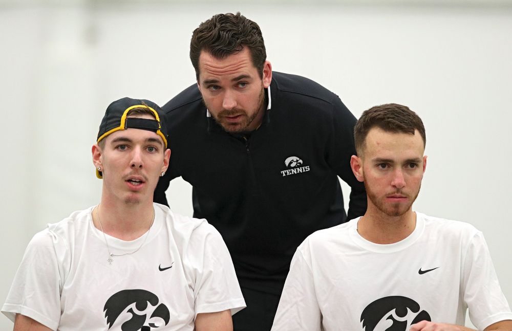 Mellecker Family Head Men's Tennis Coach Ross Wilson (center) talks with Nikita Snezhko (left) and Kareem Allaf (right) during their doubles match at the Hawkeye Tennis and Recreation Complex in Iowa City on Sunday, February 16, 2020. (Stephen Mally/hawkeyesports.com)