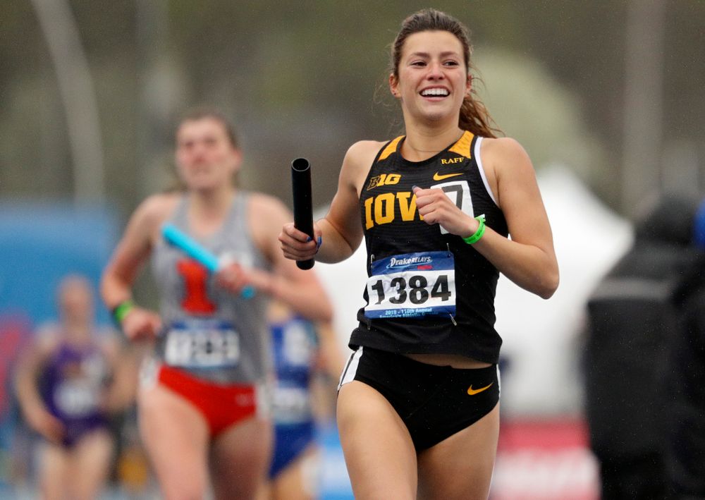 Iowa's Taylor Arco smiles as crosses the finish line while running the women's sprint medley relay event during the third day of the Drake Relays at Drake Stadium in Des Moines on Saturday, Apr. 27, 2019. (Stephen Mally/hawkeyesports.com)