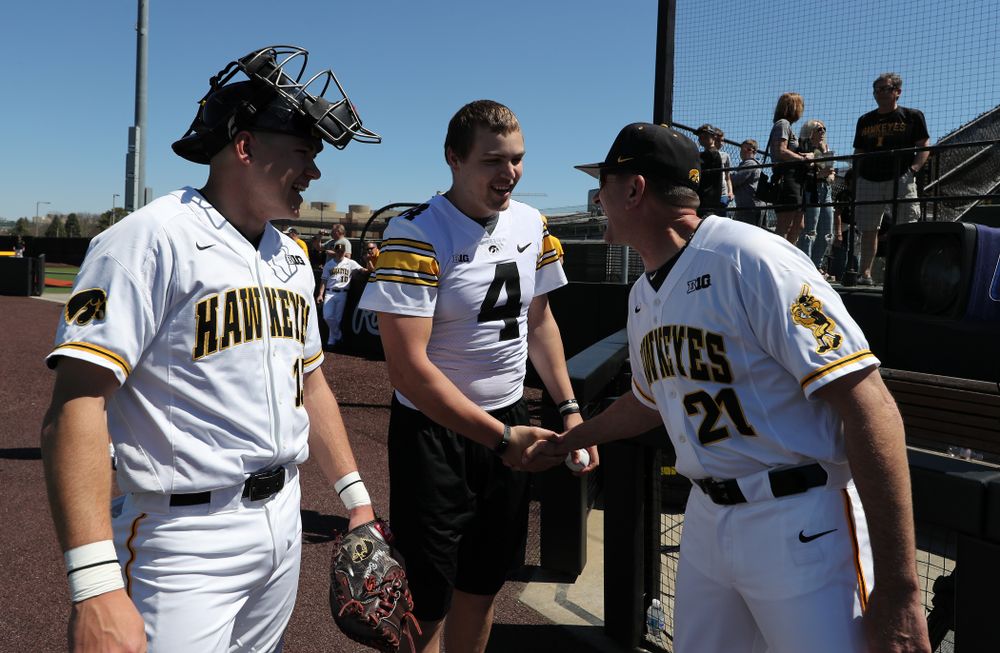 Iowa Hawkeyes quarterback Nate Stanley (4) shakes hands with Iowa Hawkeyes head coach Rick Heller before throwing out a first pitch against the Nebraska Cornhuskers Saturday, April 20, 2019 at Duane Banks Field. (Brian Ray/hawkeyesports.com)