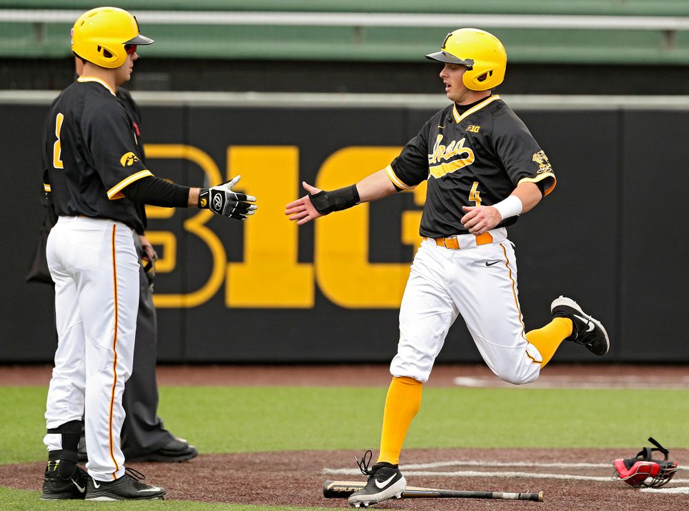 Iowa Hawkeyes second baseman Mitchell Boe (4) gets a high-five from designated hitter Luke Farley (8) after Boe scored a run during the third inning of their game against Illinois State at Duane Banks Field in Iowa City on Wednesday, Apr. 3, 2019. (Stephen Mally/hawkeyesports.com)