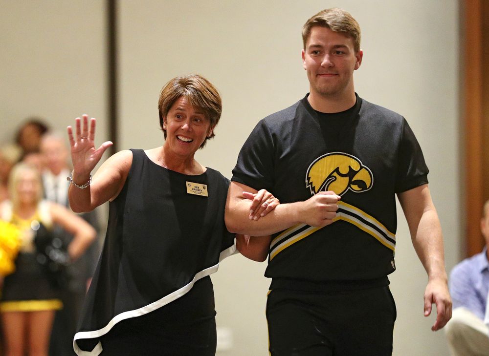 2019 University of Iowa Athletics Hall of Fame inductee Deb Brickey walks to her seat with a Spirit Squad member during the Hall of Fame Induction Ceremony at the Coralville Marriott Hotel and Conference Center in Coralville on Friday, Aug 30, 2019. (Stephen Mally/hawkeyesports.com)
