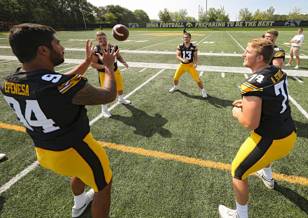 Iowa Hawkeyes defensive end A.J. Epenesa (94), defensive lineman Dalles Jacobus (66), linebacker Joe Evans (13), defensive lineman Austin Schulte (74), and defensive lineman John Waggoner (92) play around with a ball during Iowa Football Media Day at the Hansen Football Performance Center in Iowa City on Friday, Aug 9, 2019. (Stephen Mally/hawkeyesports.com)