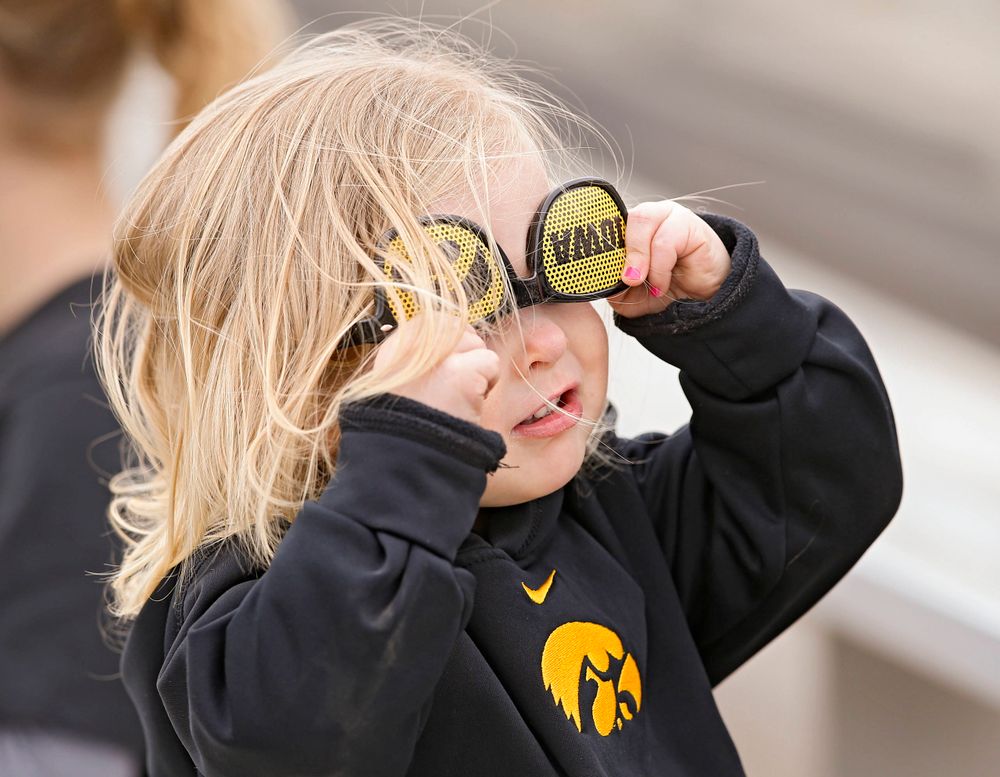 A young fan tries on some sunglasses during the second inning of their Big Ten Conference softball game at Pearl Field in Iowa City on Friday, Mar. 29, 2019. (Stephen Mally/hawkeyesports.com)