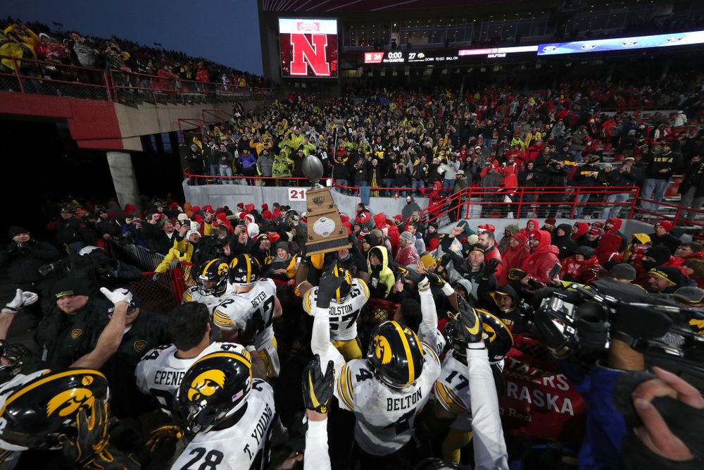Iowa Hawkeyes defensive end Chauncey Golston (57) carries the Heroes Game trophy off the field following their win against the Nebraska Cornhuskers Friday, November 29, 2019 at Memorial Stadium in Lincoln, Neb. (Brian Ray/hawkeyesports.com)