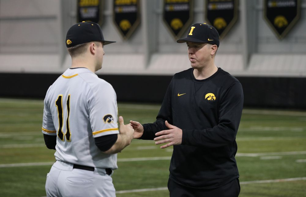 Iowa Hawkeyes Cole McDonald (11) talks with pitching coach Tom Gorzelanny during the team's annual media day Tuesday, February 5, 2019 in the Indoor Practice Facility. (Brian Ray/hawkeyesports.com)