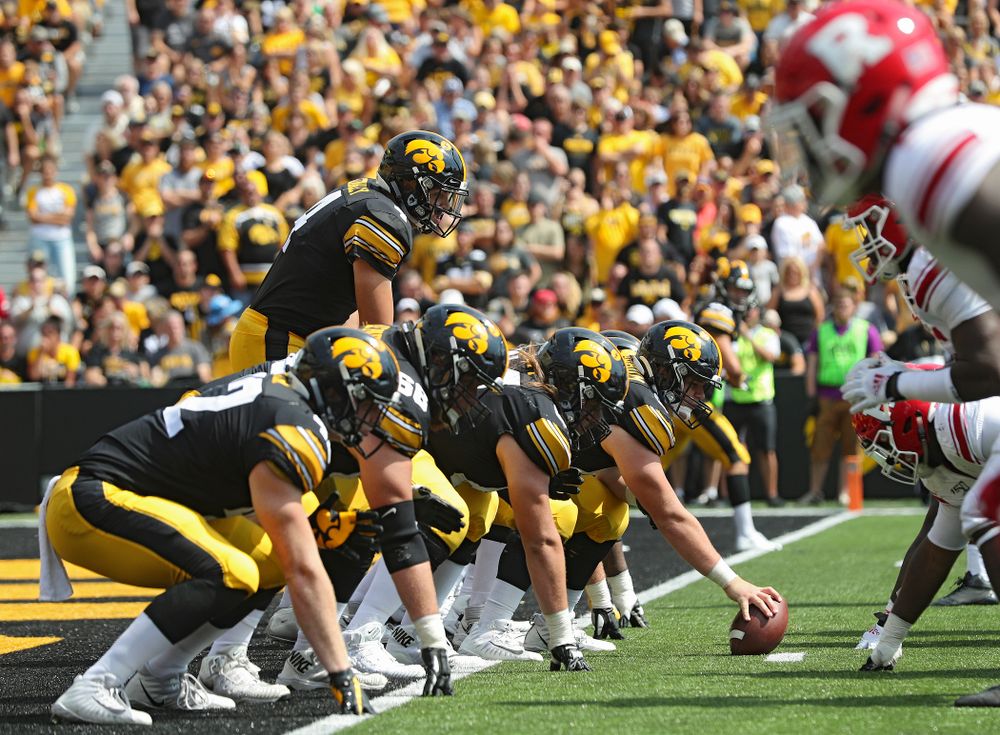 Iowa Hawkeyes quarterback Nate Stanley (4) prepares for a snap from offensive lineman Tyler Linderbaum (65) during the third quarter of their Big Ten Conference football game at Kinnick Stadium in Iowa City on Saturday, Sep 7, 2019. (Stephen Mally/hawkeyesports.com)