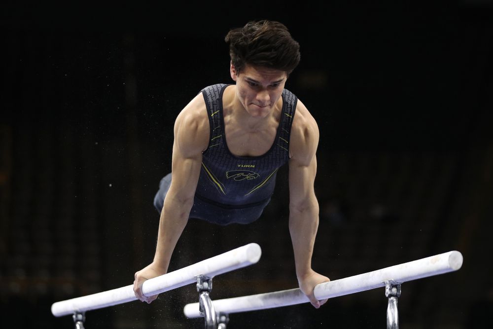 Iowa's Evan Davis competes on the parallel bars against the Ohio State Buckeyes  Saturday, March 16, 2019 at Carver-Hawkeye Arena.  (Brian Ray/hawkeyesports.com)