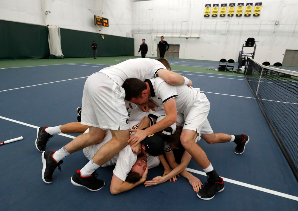 Iowa's Piotr Smietana celebrates with his teammates after clinching the match against Purdue Sunday, April 15, 2018 at the Hawkeye Tennis an