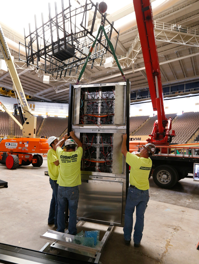 Workers install the video board at the south end of Carver.