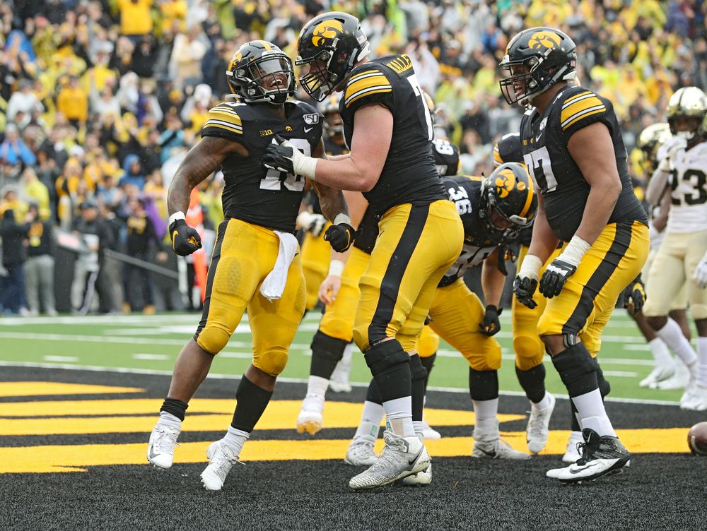 Iowa Hawkeyes running back Mekhi Sargent (10) celebrates his touchdown run with offensive lineman Mark Kallenberger (71) during the fourth quarter of their game at Kinnick Stadium in Iowa City on Saturday, Oct 19, 2019. (Stephen Mally/hawkeyesports.com)