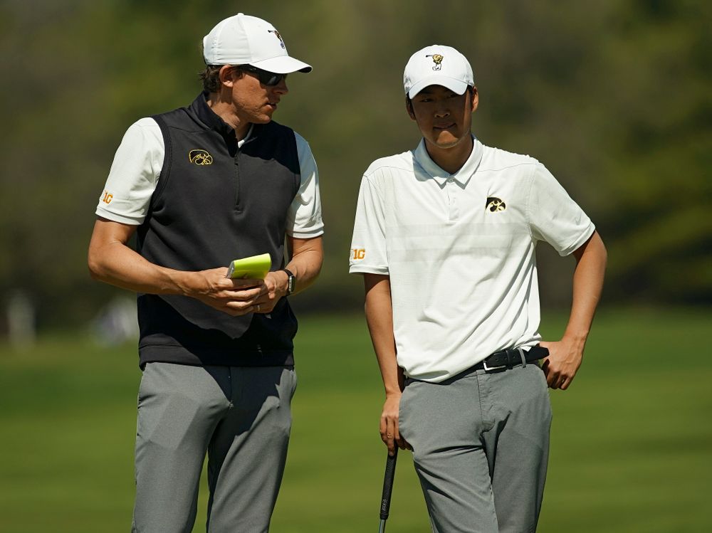 Iowa assistant coach Charlie Hoyle (from left) talks with Joe Kim during the second round of the Hawkeye Invitational at Finkbine Golf Course in Iowa City on Saturday, Apr. 20, 2019. (Stephen Mally/hawkeyesports.com)