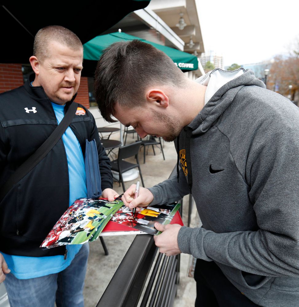 Keith Duncan autographing photos of the game-winning field goal at Nebraska 